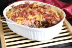keto bacon cheeseburger casserole with one serving taken out shows the layers of cheese, meat, and bacon